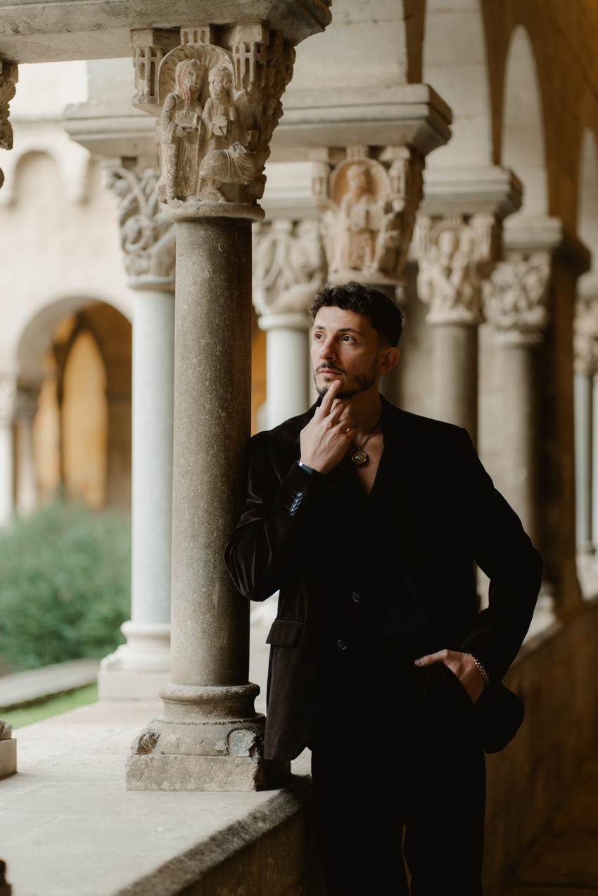 Michael standing in a stone cloister, looking into the distance